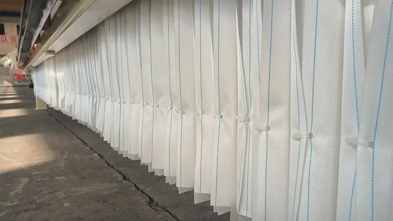 Filter press cloth fitted to a filter plate showing the feed opening and attachment arrangement Filter press cloth fitted to a filter plate showing the feed opening and attachment arrangement